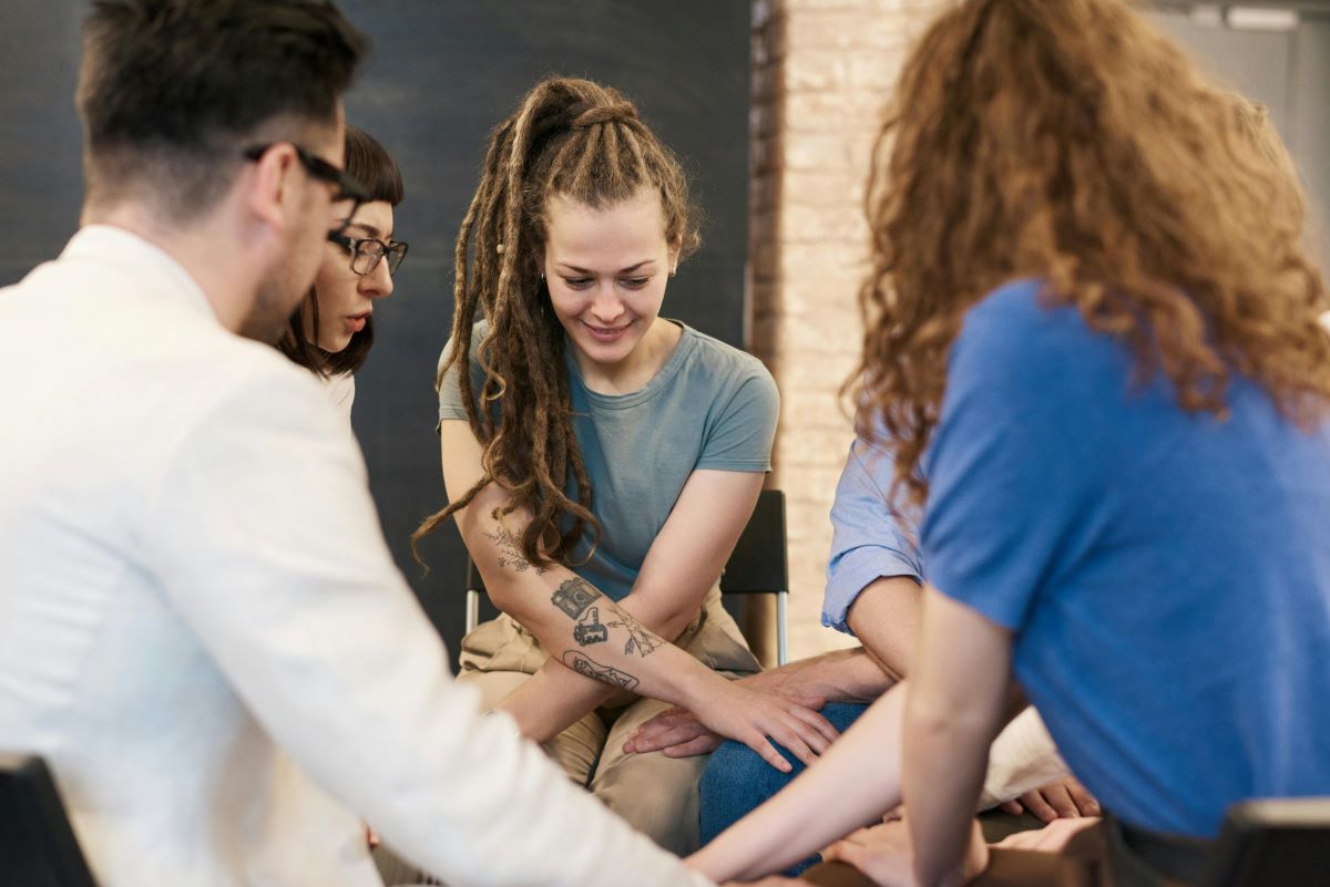 Peers holding hands in a circle during peer support